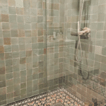 Portugese tegel op de vloer en zelliges aan de wand in douche badkamer ruimte